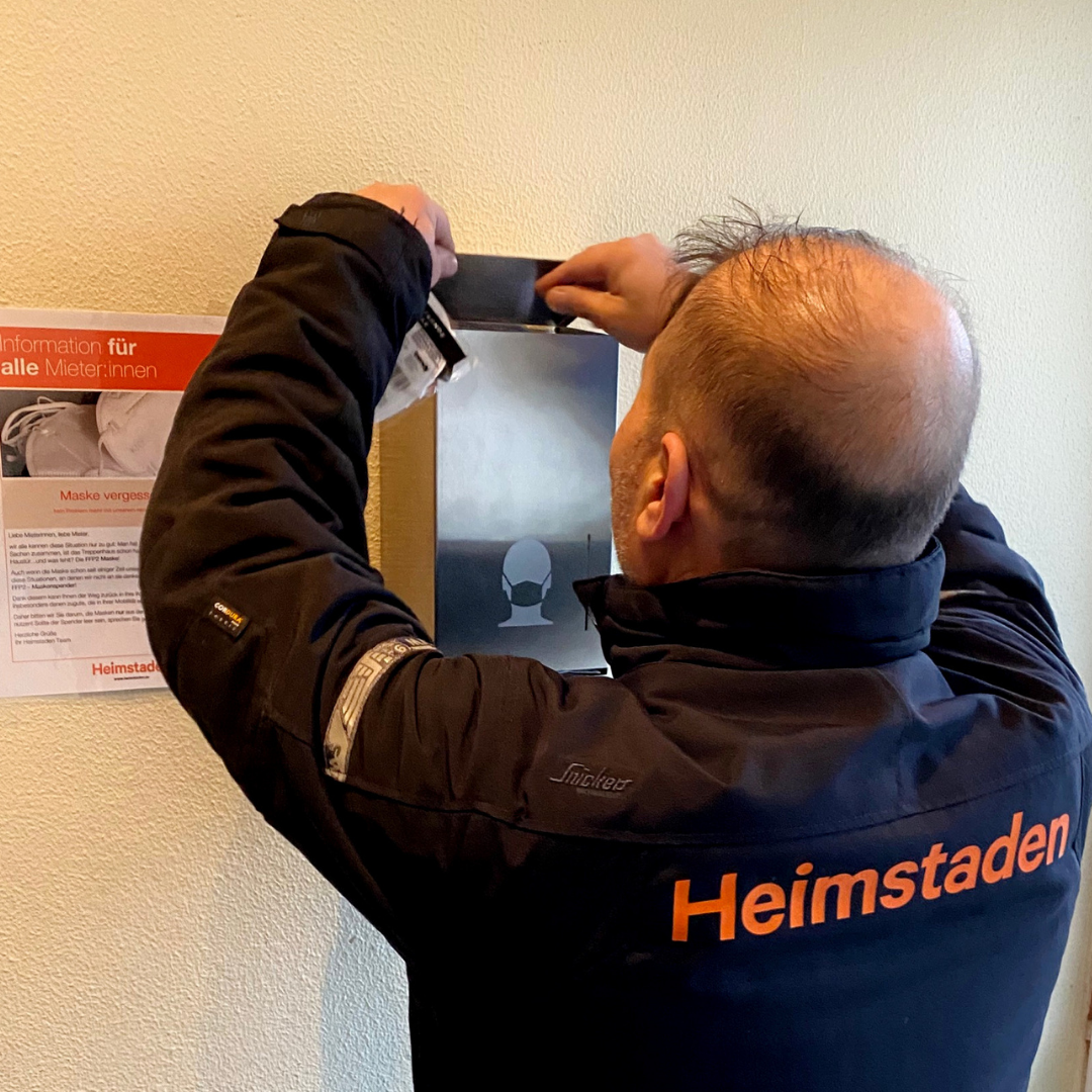 Hausmeister Memed mit Maskenspender Pilotprojekt